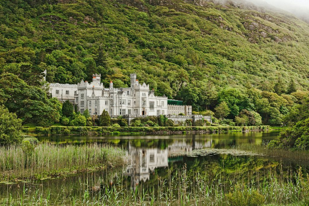 Abbazia di Kylemore, Connemara, Irlanda, circondata da foreste e riflessa nel lago.