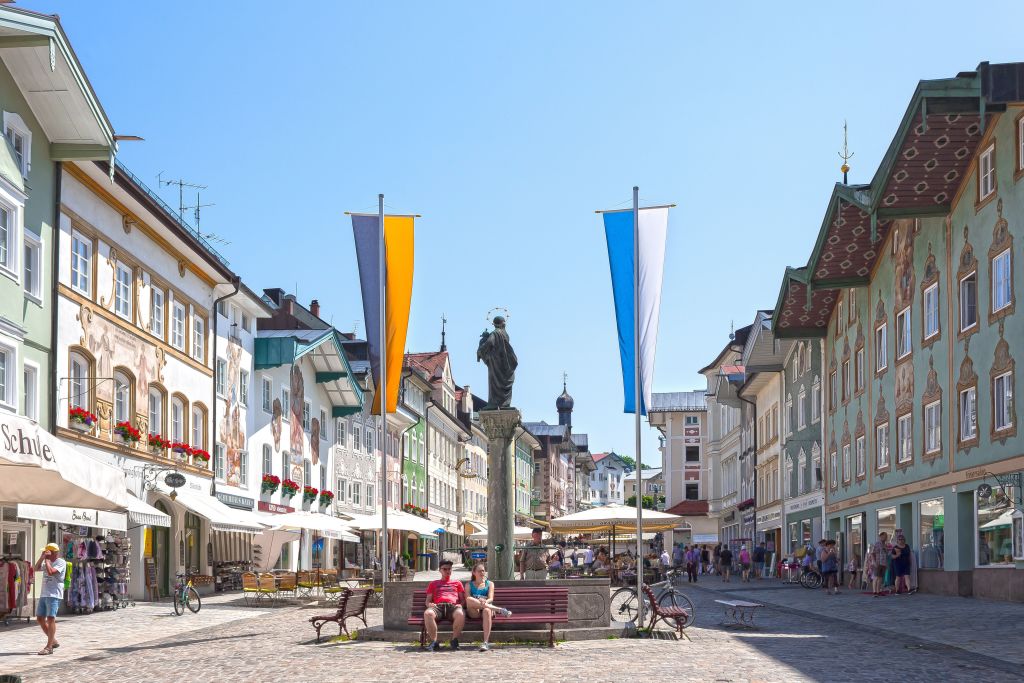Piazza centrale di Bad Tölz, Baviera, Germania, con edifici colorati e bandiere bavaresi.
