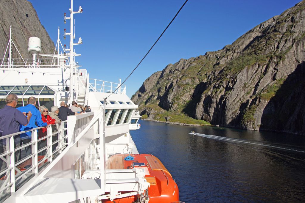 Traghetto che attraversa un fiordo con montagne ripide ai lati, vacanze in bici e barca "Girolibero"