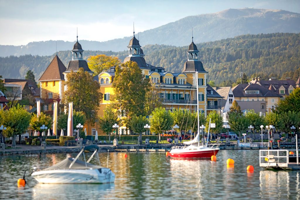 Veduta del castello di Velden am Wörthersee affacciato sul lago tra le montagne