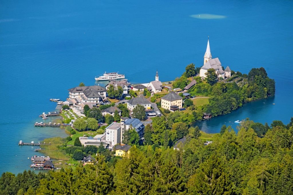 Veduta aerea di un castello e di un lago nella regione di Villach, Carinzia.