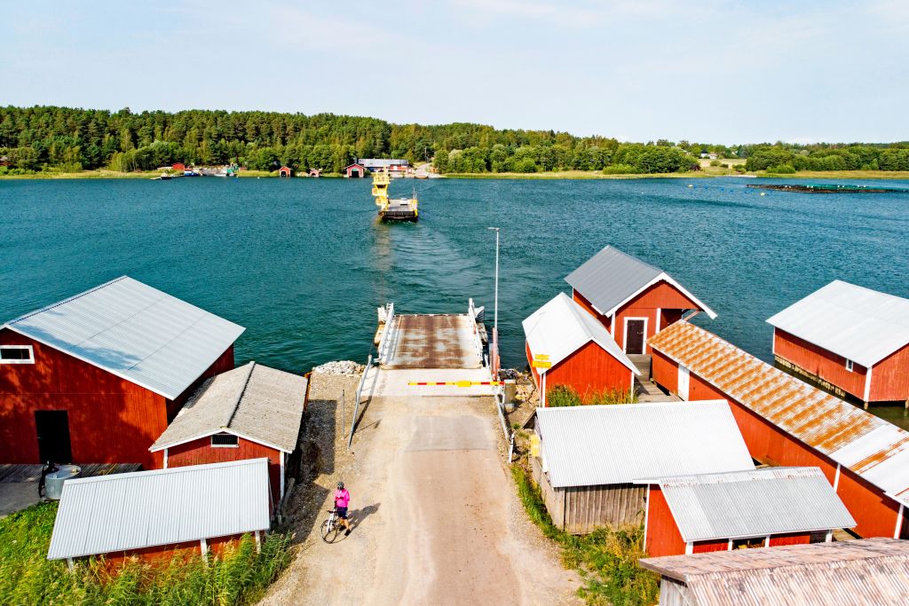 Vista di case tradizionali in legno rosso sull'acqua, nel pittoresco arcipelago di Turku.