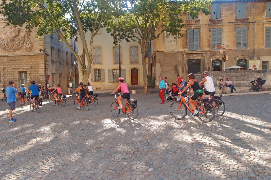 Gruppo di ciclisti in sosta davanti a un edificio storico in Provenza, Francia, vacanza in bici e barca con Girolibero