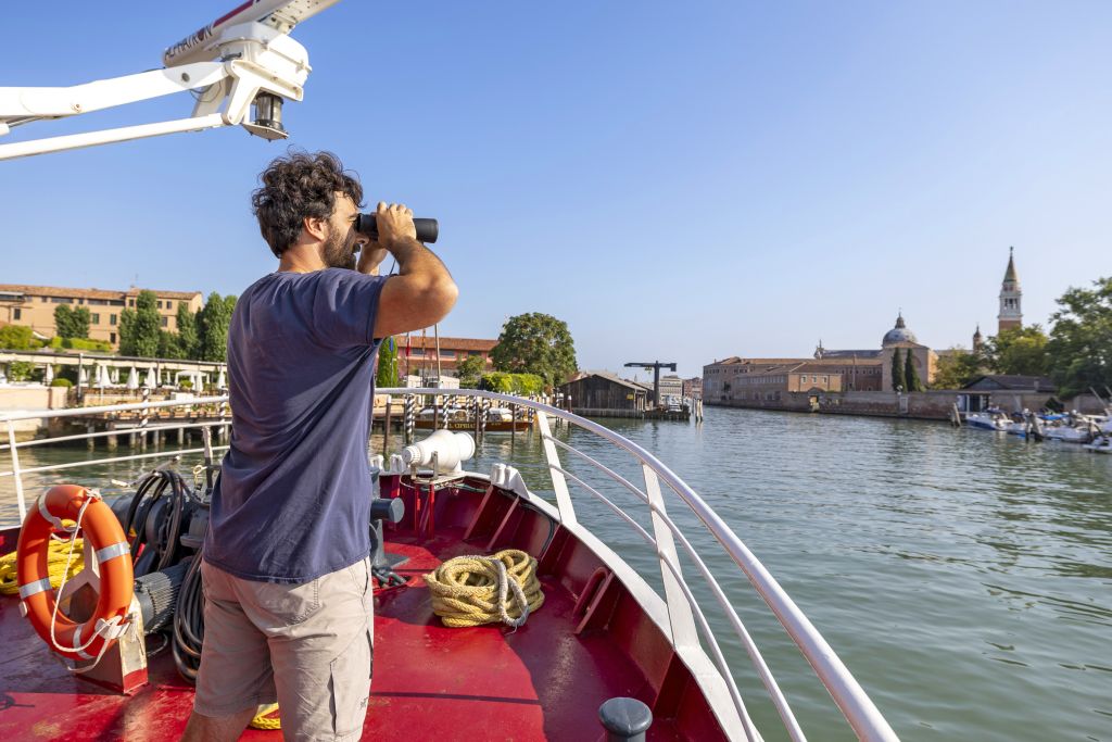 Persona ammira il paesaggio con un binocolo dal ponte di "Ave Maria"