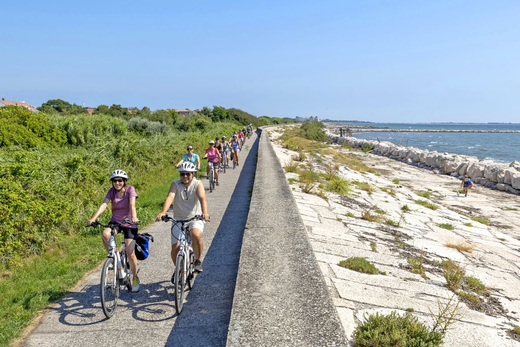 Gruppo in bici su una pista ciclabile nella laguna veneta