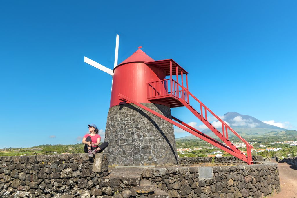 Mulino a vento rosso tradizionale sull'isola di Pico, Azzorre, con cielo azzurro.