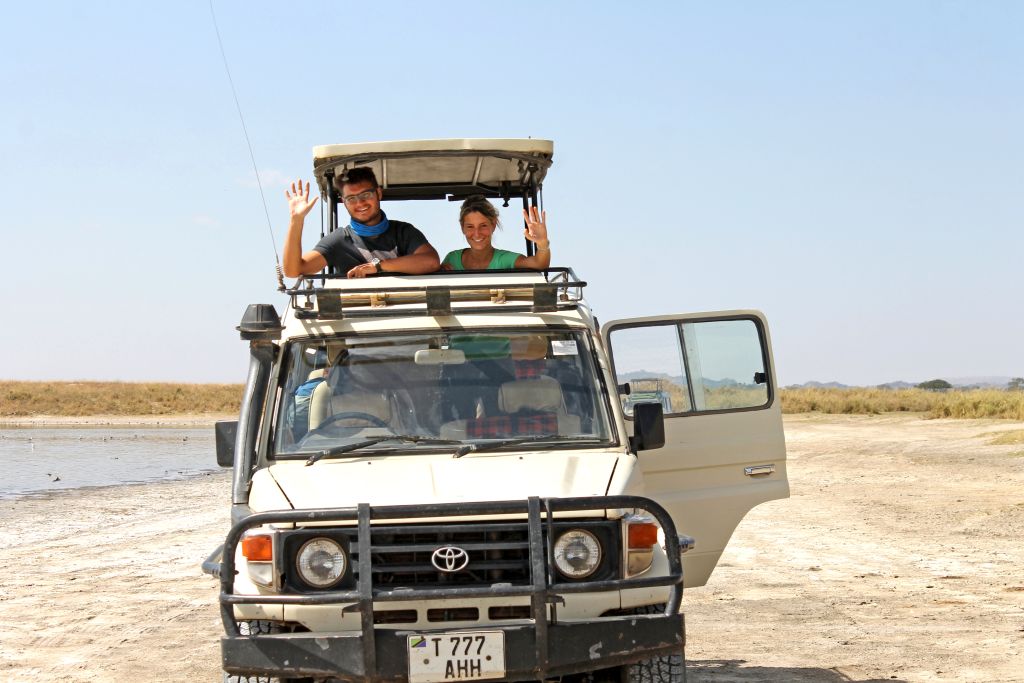Viaggiatore osserva un elefante attraverso la finestra aperta di una jeep durante un safari.