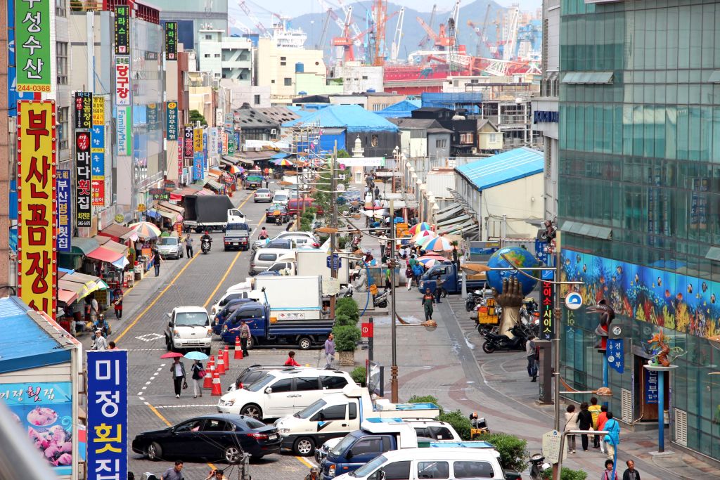 Strada affollata con negozi e insegne luminose, Corea del Sud.