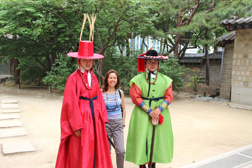 Persone in abiti tradizionali coreani hanbok davanti a un tempio.