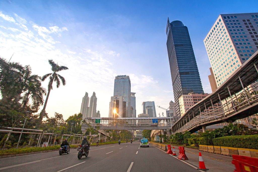 Grattacieli di Giacarta, Indonesia – Strada trafficata con moderni edifici di vetro nella capitale indonesiana.