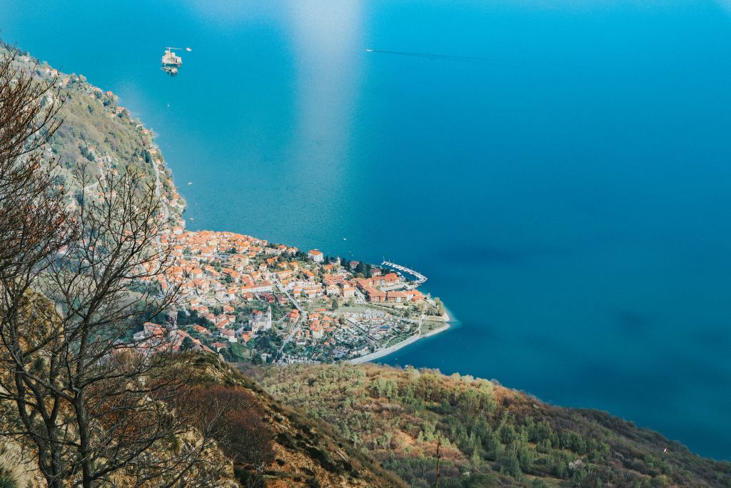 Vista panoramica sul Lago Maggiore con acque cristalline e imbarcazioni, dall’alto della Via delle Genti.