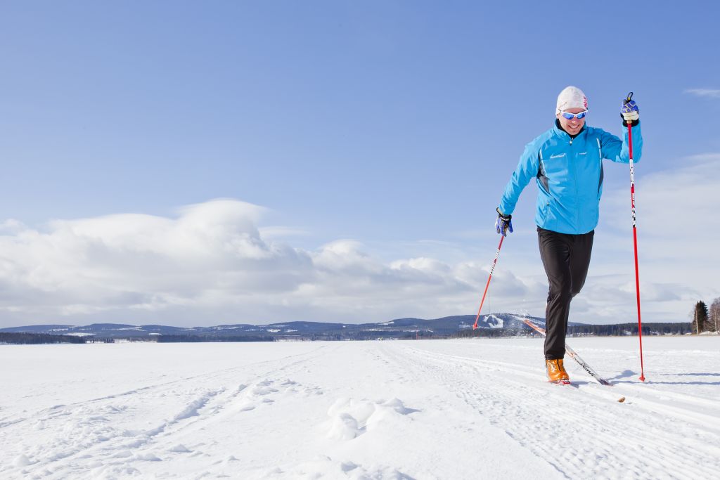 Uomo che pratica sci di fondo su un lago ghiacciato in Lapponia, Finlandia.