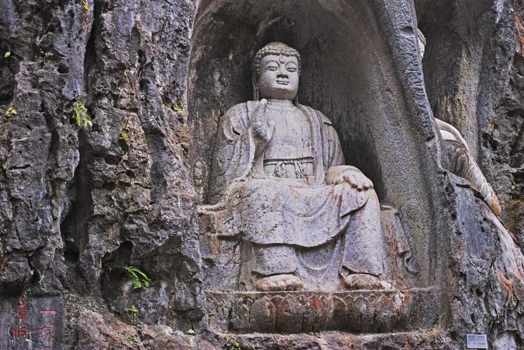 Statua di Buddha scolpita nella roccia al Tempio Lingyin di Hangzhou, meta spirituale lungo un tour culturale