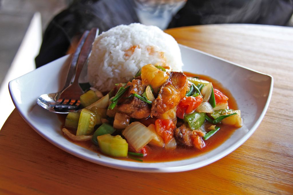 Piatto fumante di riso jasmine e curry di verdure in ristorante tipico laotiano
