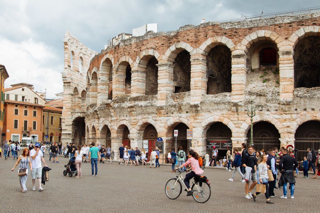 Touristen und Radfahrer vor der Arena von Verona, Italien.