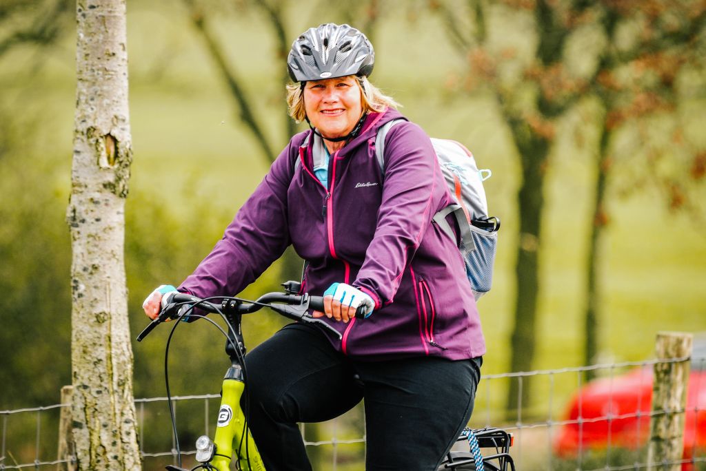Smiling cyclist in sportswear riding through a Dutch park
