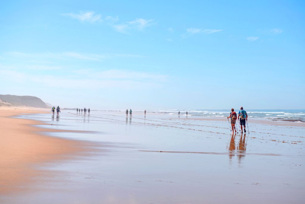Escursionisti che camminano lungo una spiaggia dell'Alentejo, Portogallo