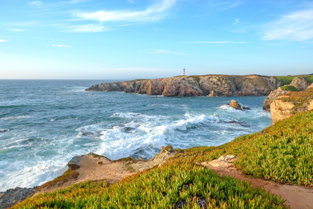 Scogliere rocciose e onde oceaniche lungo la costa dell'Alentejo, Portogallo.