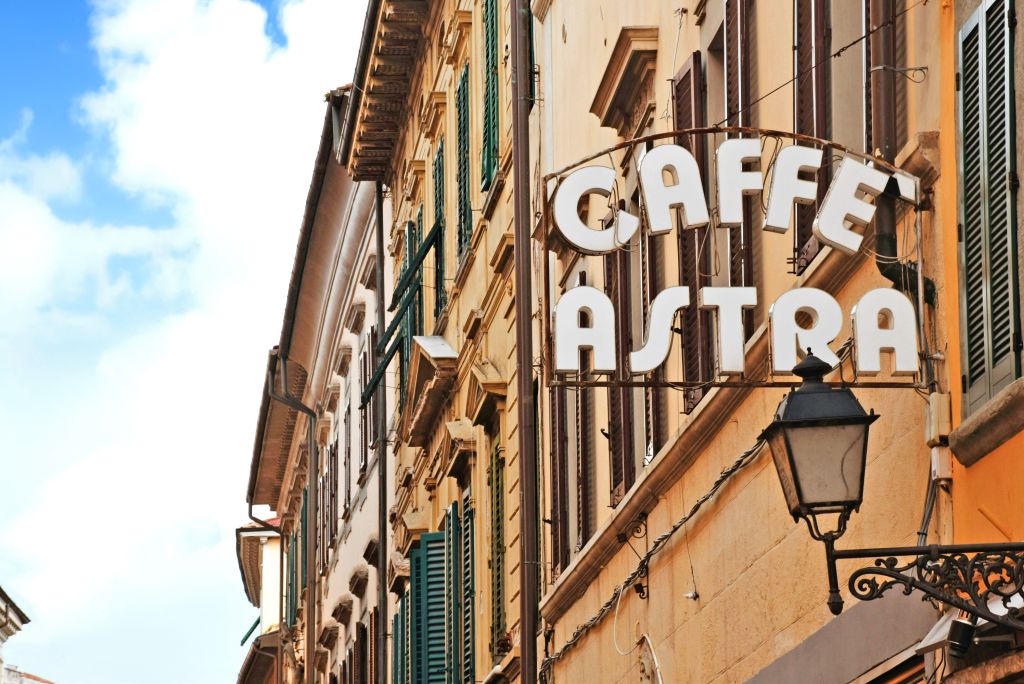 L’insegna del "Caffè Astra" su una facciata storica nel centro di Lucca, Toscana, Italia.