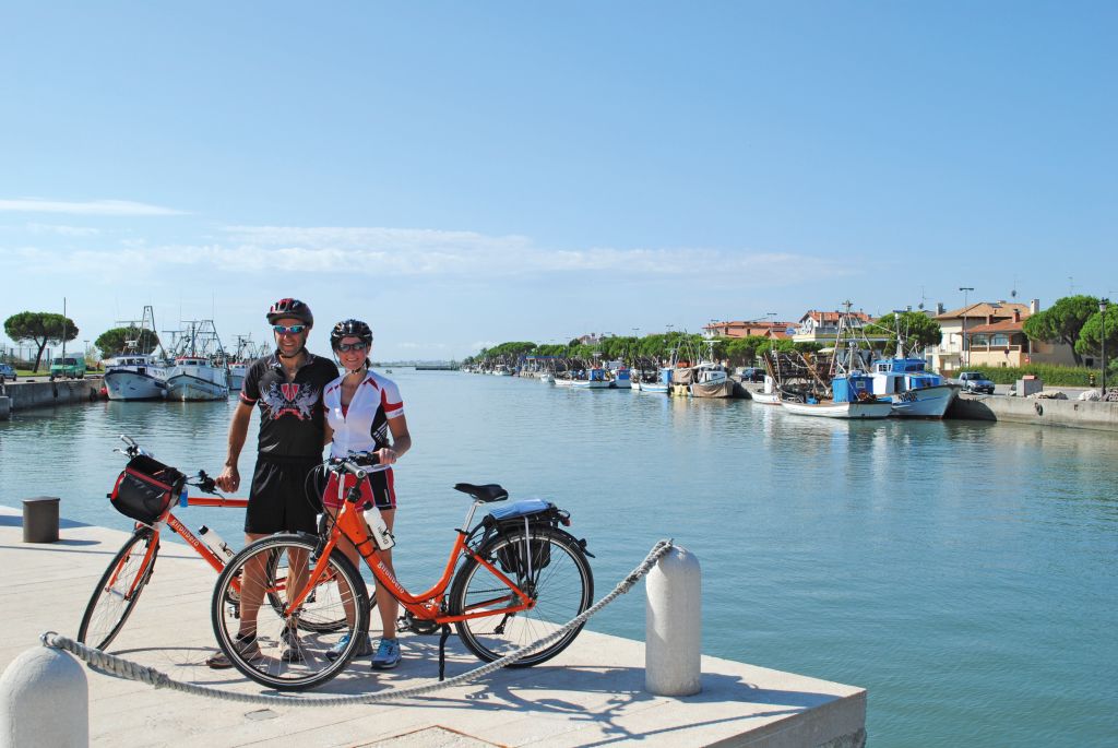 Vacanze in bicicletta, coppia di ciclisti in posa nel porto, Ciclovia Adriatica, viaggi in bici organizzati "Girolibero"