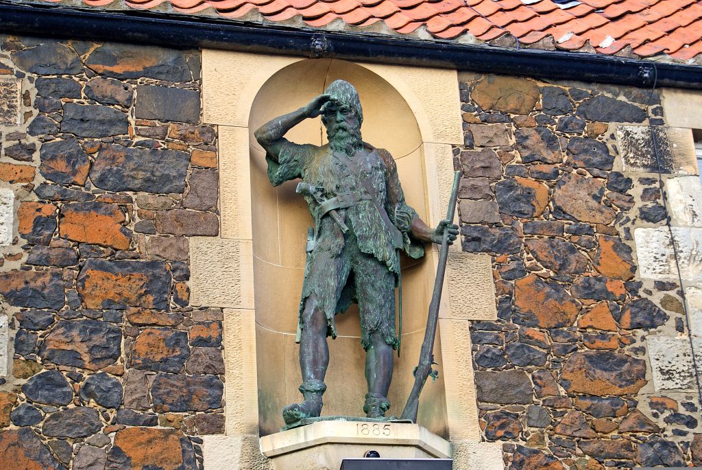 Statua di un santo sulla facciata di una chiesa storica a St Andrews, Scozia.