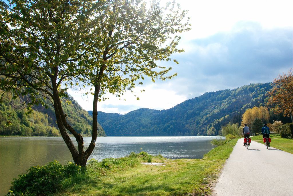 Coppia di cicloturisti, ciclabile del Danubio, paesaggio verde di montagna, tra Passau e Vienna, Austria