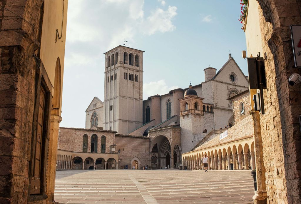 La Piazza Inferiore di San Francesco ad Assisi con la Basilica e il cielo azzurro.