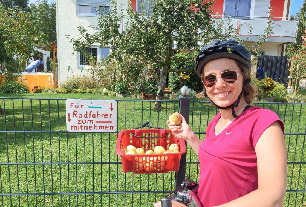 Ciclista sorridente in pausa davanti a una casa con giardino, viaggi in bici "Girolibero"