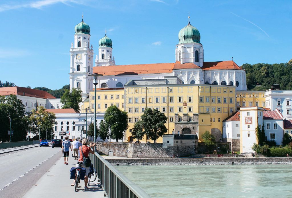 Ciclisti attraversano il ponte sul Danubio con vista sulla Duomo di Passau