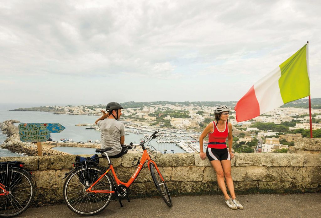 Zwei Radtouristen machen eine Pause an einer Wand gelehnt im Salento, "Girolibero“-Radurlaub