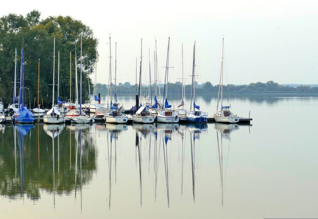 Barche a vela ormeggiate in porto sul Lago di Müritz, regione del Meclemburgo-Pomerania, Germania.