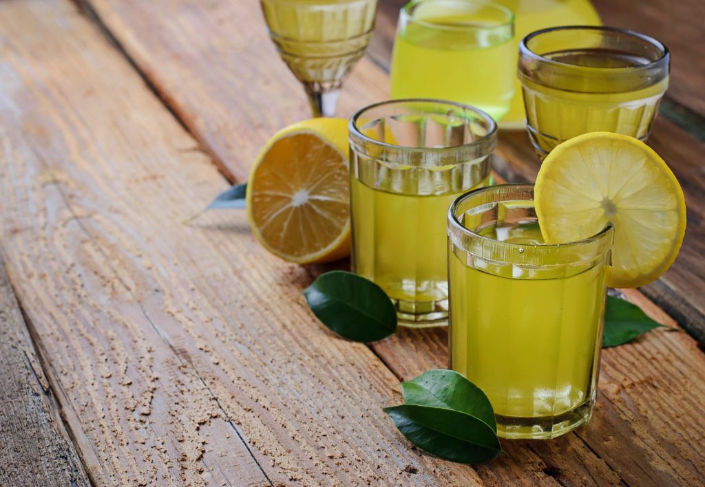 Bicchieri di limoncello con fette di limone, bevanda tipica della Costiera Amalfitana, Italia.