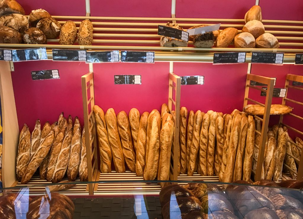 Window of a bakery with fresh baguettes on display in a location in the Loire Valley.