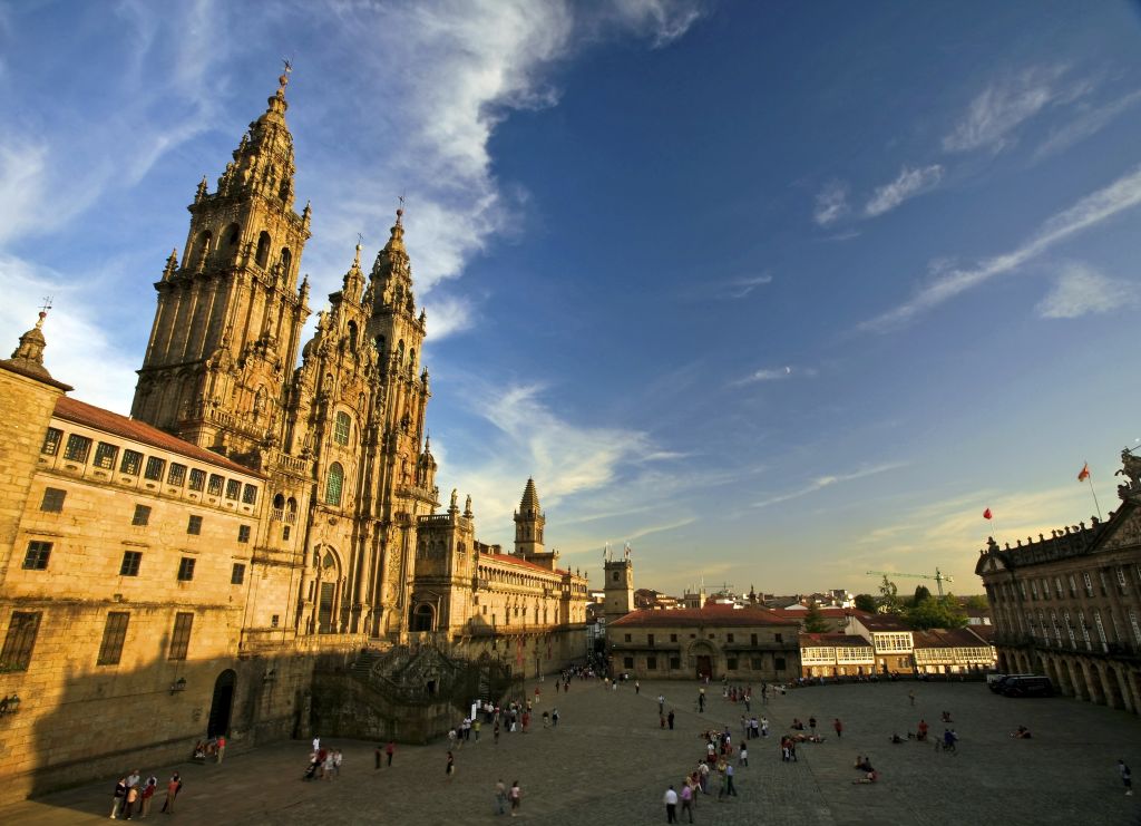 Vista della maestosa facciata della Cattedrale di Santiago de Compostela illuminata dalla luce del tramonto.
