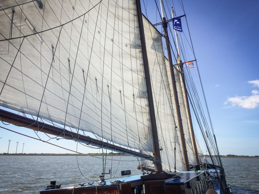 Vele spiegate di una barca a vela che solca le acque del Mare del Nord.