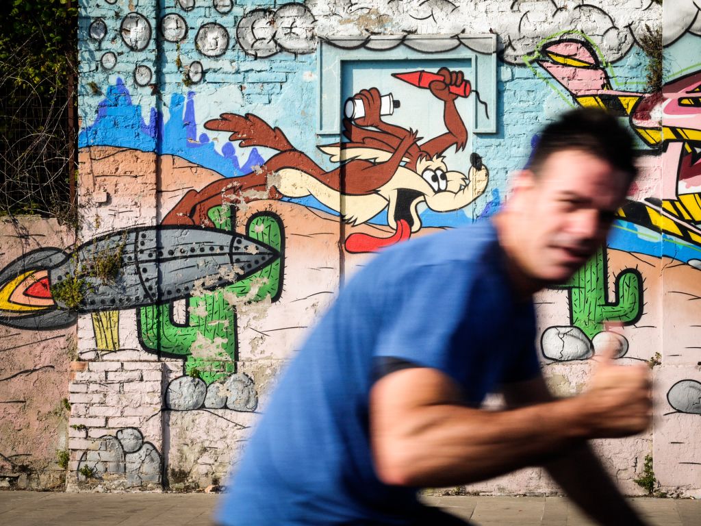 Ciclista che passa davanti a un murales