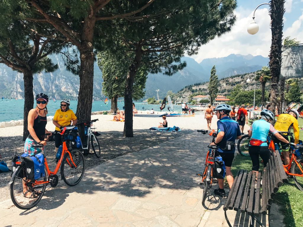 Ciclisti in viaggio con "Girolibero", pausa all'ombra degli alberi, in bici sul lago di Garda