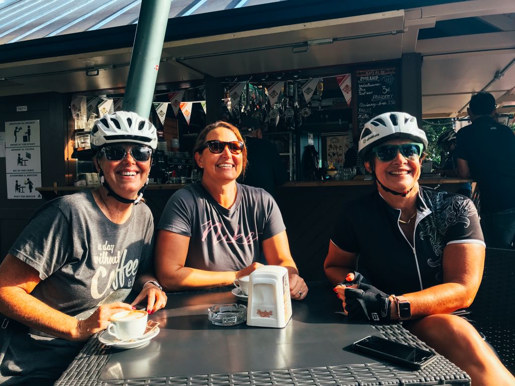 Gruppe von Radfahrern, die eine Kaffeepause in einem Café entlang der Route einlegt, Italien.