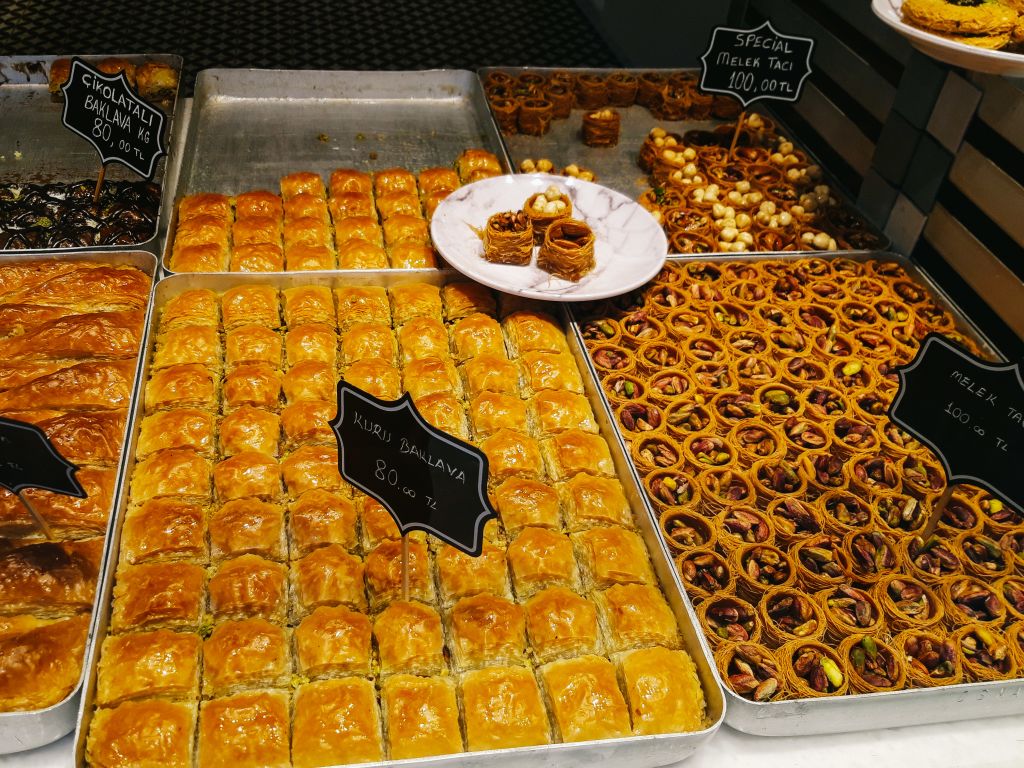 Banco di dolci tipici turchi in una pasticceria locale, con baklava e dolcetti alle noci.