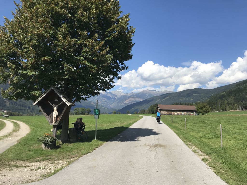 cicloturista, paesaggio verde pianeggiante, sfondo collinare, ciclabile della Drava in Austria