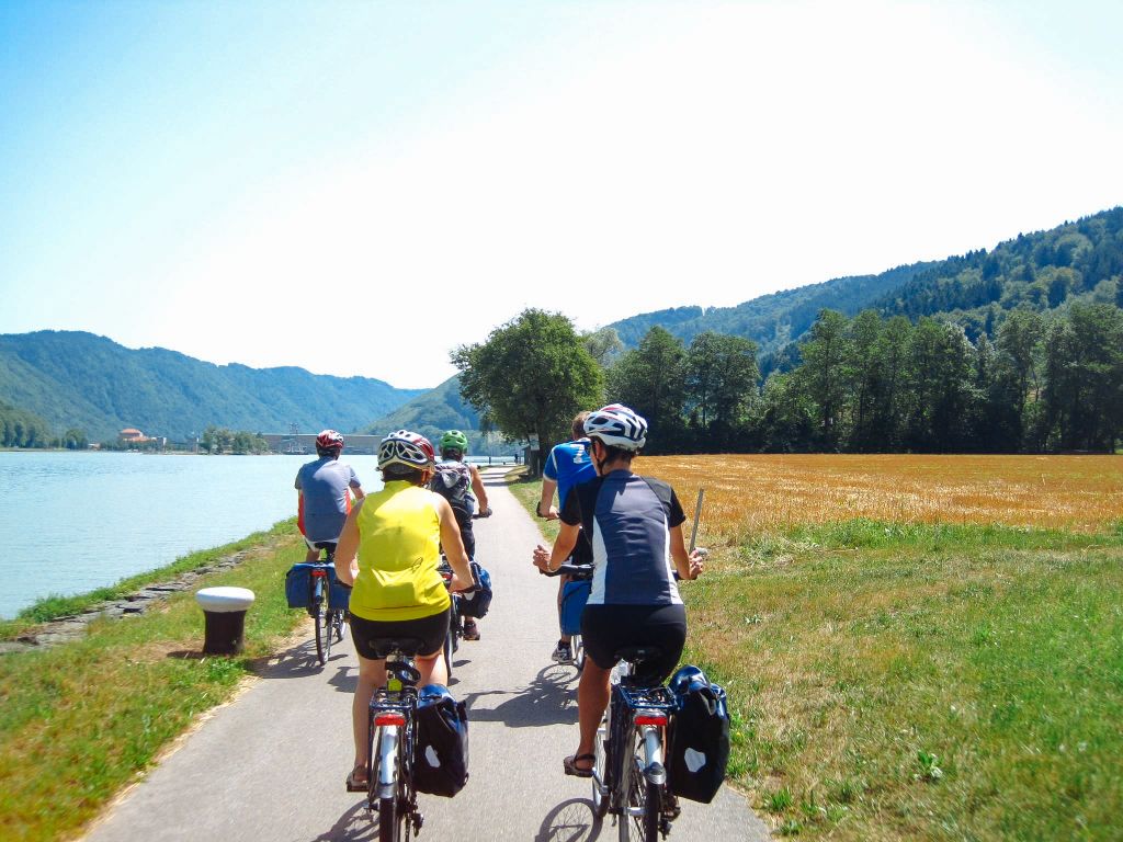 Gruppo di cicloturisti con caschetto, paesaggio verde, fiume Danubio, tra Passau e Vienna, slow tourism, Austria