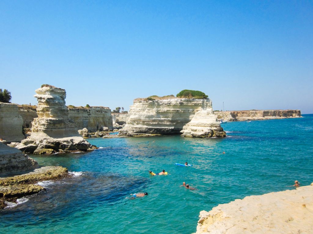 Scogliera con acqua turchese e rocce vicino alla Grotta della Poesia, Salento.