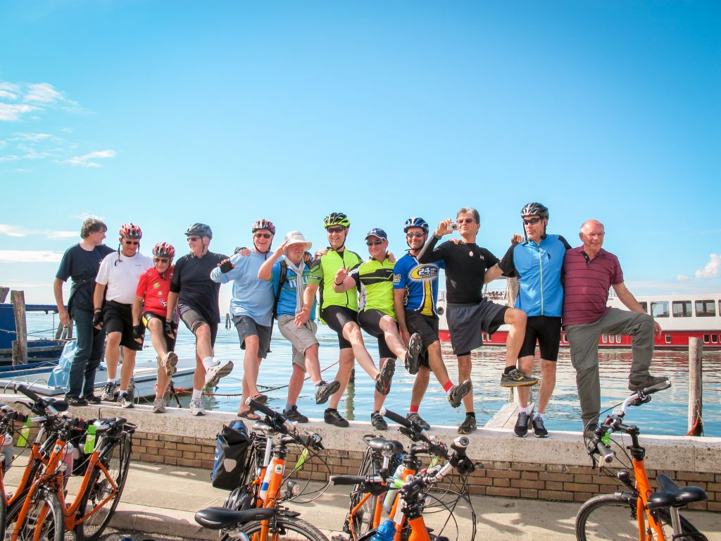 Gruppo di ciclisti in posa per una foto con bici Girolibero in primo piano e mare sullo sfondo