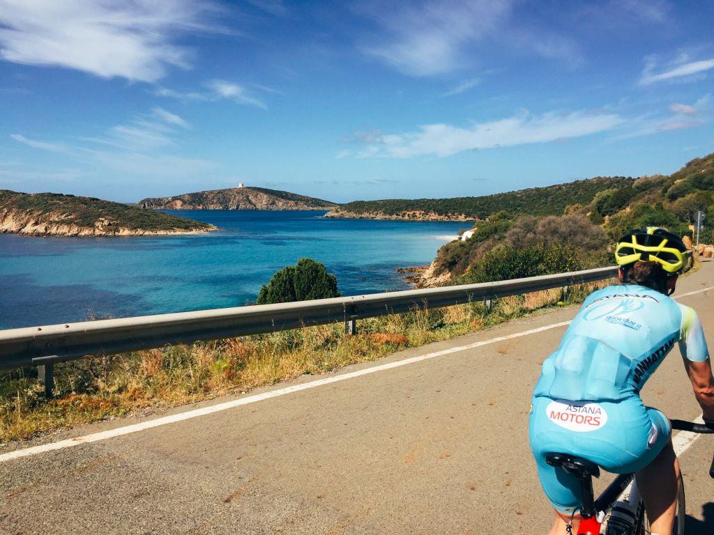 Panorama di ciclisti su una strada costiera con vista sul mare, Sardegna roadbike tour