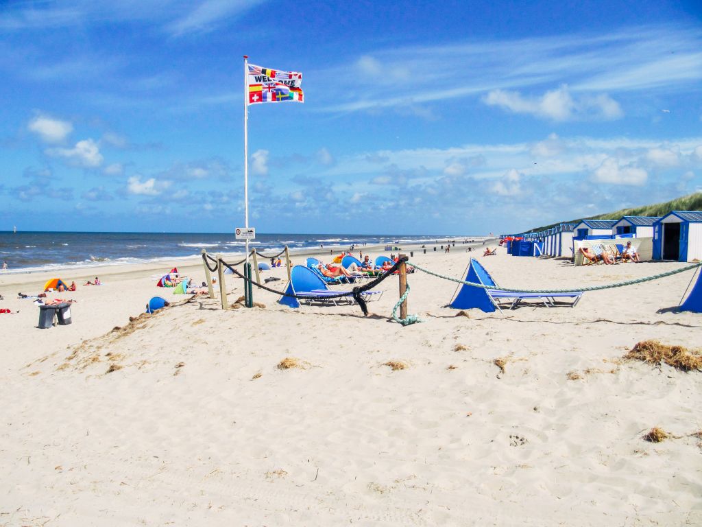 Sandy beach with a flag and dunes on Texel Island, Netherlands