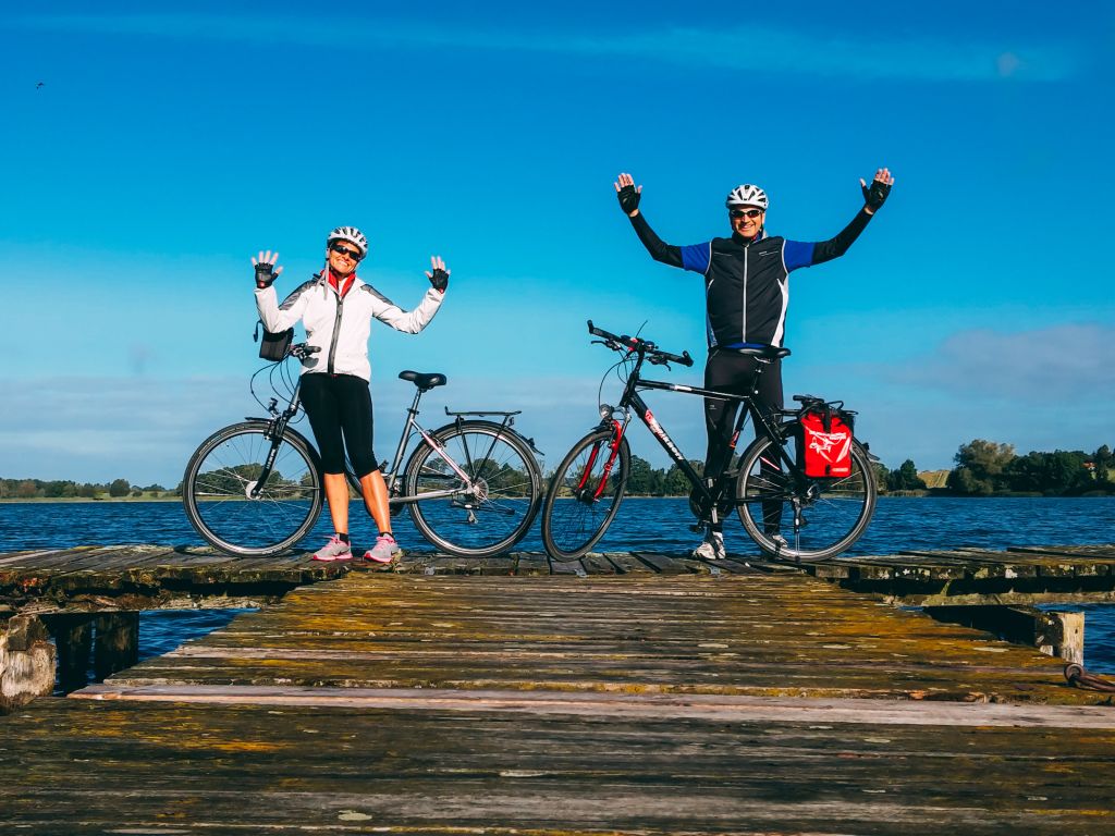 Ciclisti festeggiano l'arrivo su un pontile in legno vicino al mare del Nord