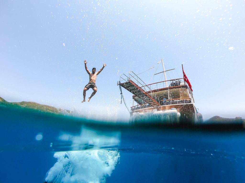Dive from a boat into the crystal-clear waters of the Saronic Gulf, Greece.