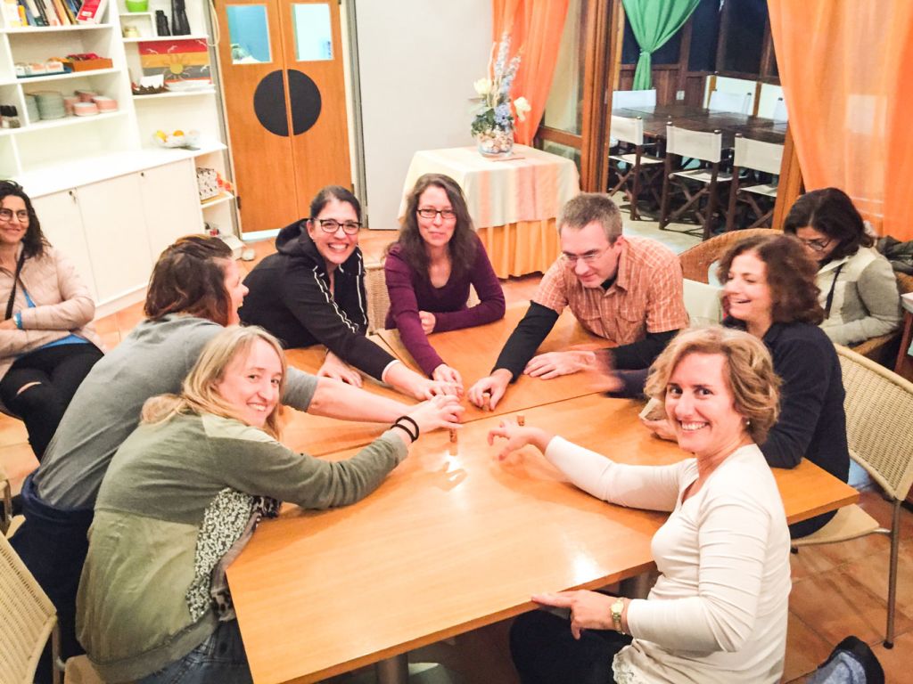 Gruppo di viaggiatori seduti intorno a un tavolo in una sala accogliente, trekking organizzati "Girolibero"