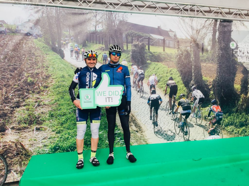 Ciclisti che si abbracciano sorridenti dopo la gara, premiazione con medaglie al collo.