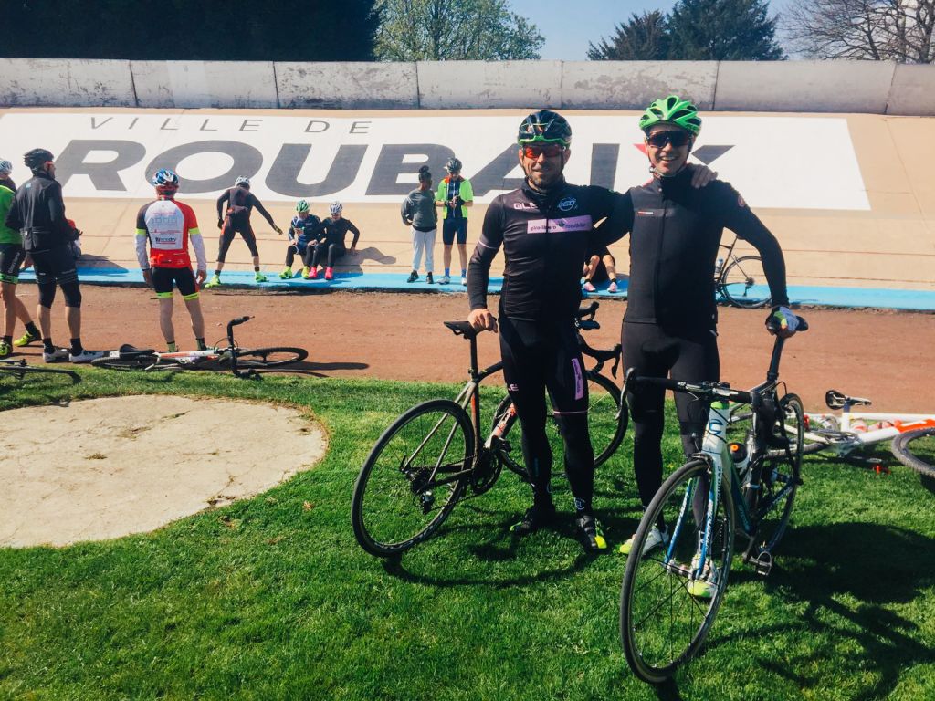 Due ciclisti in posa all'arrivo dentro al velodromo, giro delle Fiandre in bici da corsa